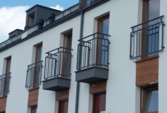 Balustrady balkonowe na elewacji ceglanej
